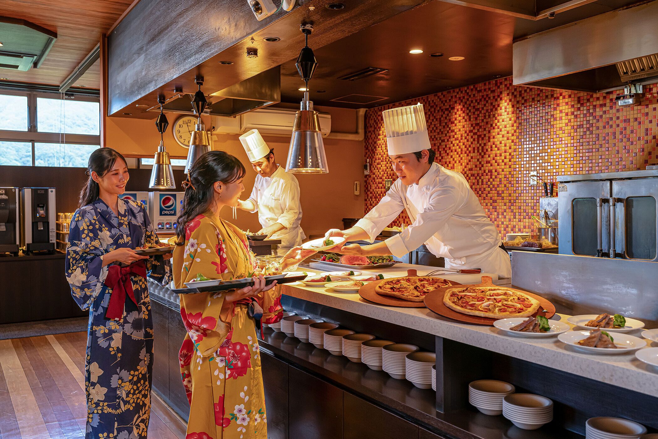 A restaurant kitchen with chefs preparing food, a buffet counter with various dishes, and a clock on the wall.