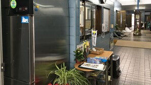 Een professionele keuken met roestvrijstalen apparatuur, een klok en een T-POINT bord.