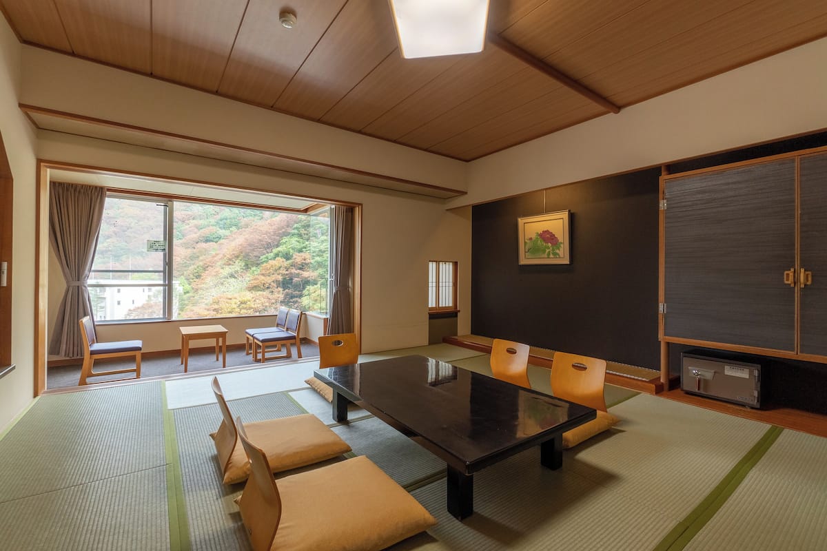 Een traditionele Japanse kamer met tatami vloerbedekking, een lage tafel en zitplaatsen.
