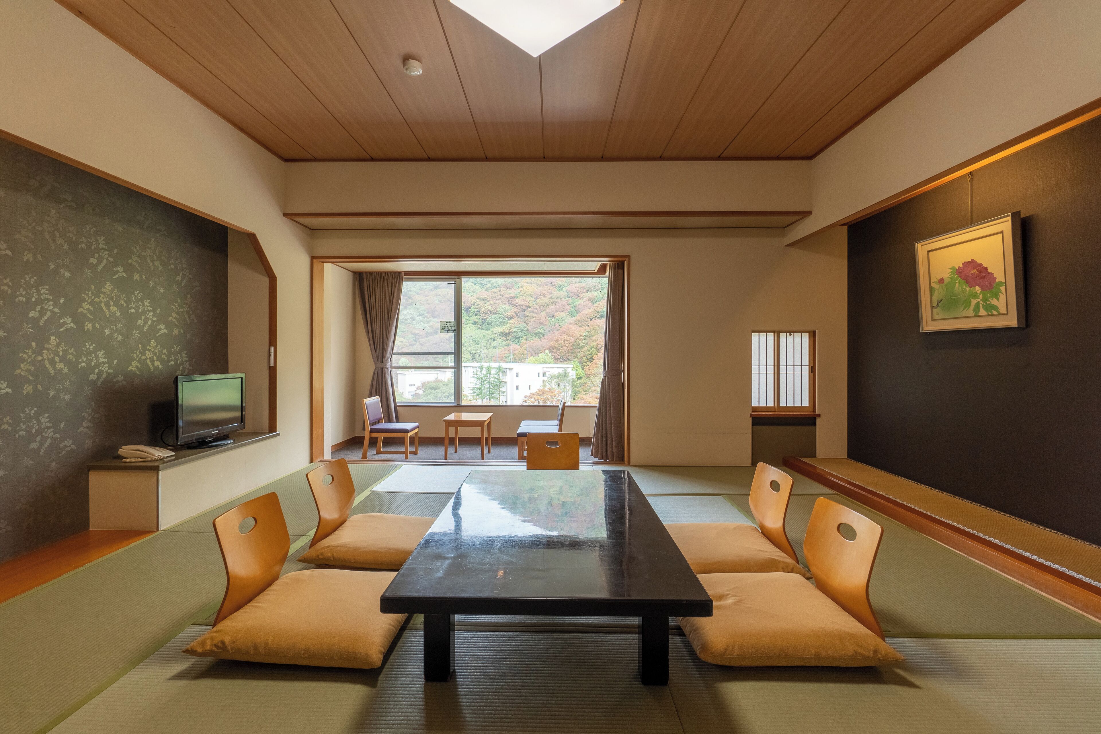 A traditional Japanese-style room with tatami flooring, a low table, and cushions.