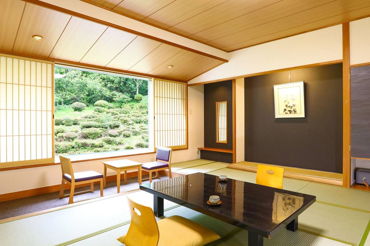 Een traditionele Japanse kamer met tatami vloerbedekking, een lage tafel en shoji schuifwanden.