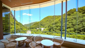 Un balcon doté de meubles en osier et offrant une vue panoramique sur les montagnes.