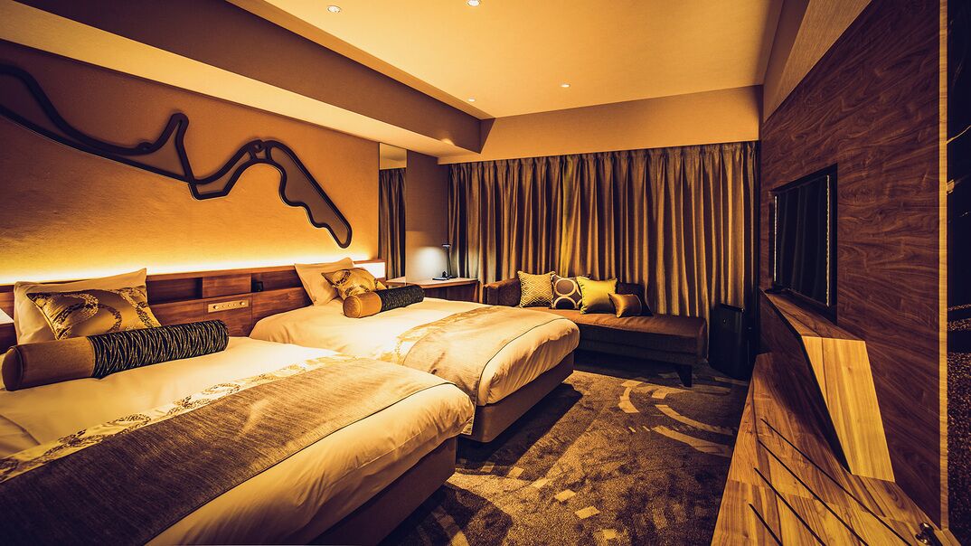 Ein modernes Hotelzimmer mit zwei Betten, einem großen Spiegel, einem Fernseher und einer Wand mit Holzvertäfelung.