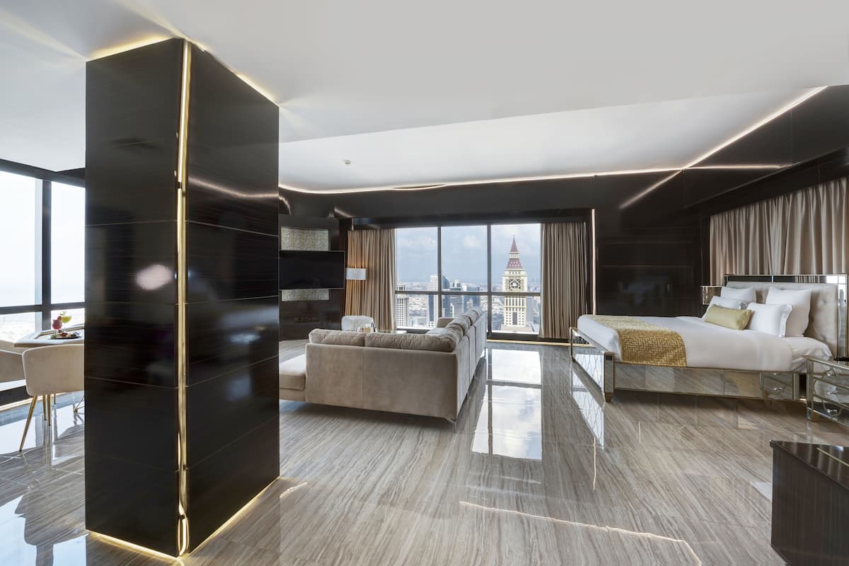 Une chambre d’hôtel moderne dotée d’une grande fenêtre, d’un lit, d’un canapé et d’un mur d’accent noir.