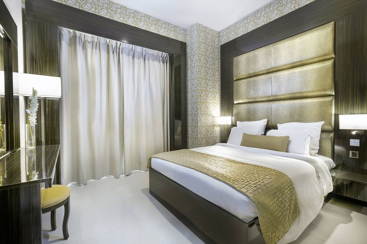 Une chambre d’hôtel moderne avec un grand lit, un bureau et une chaise.