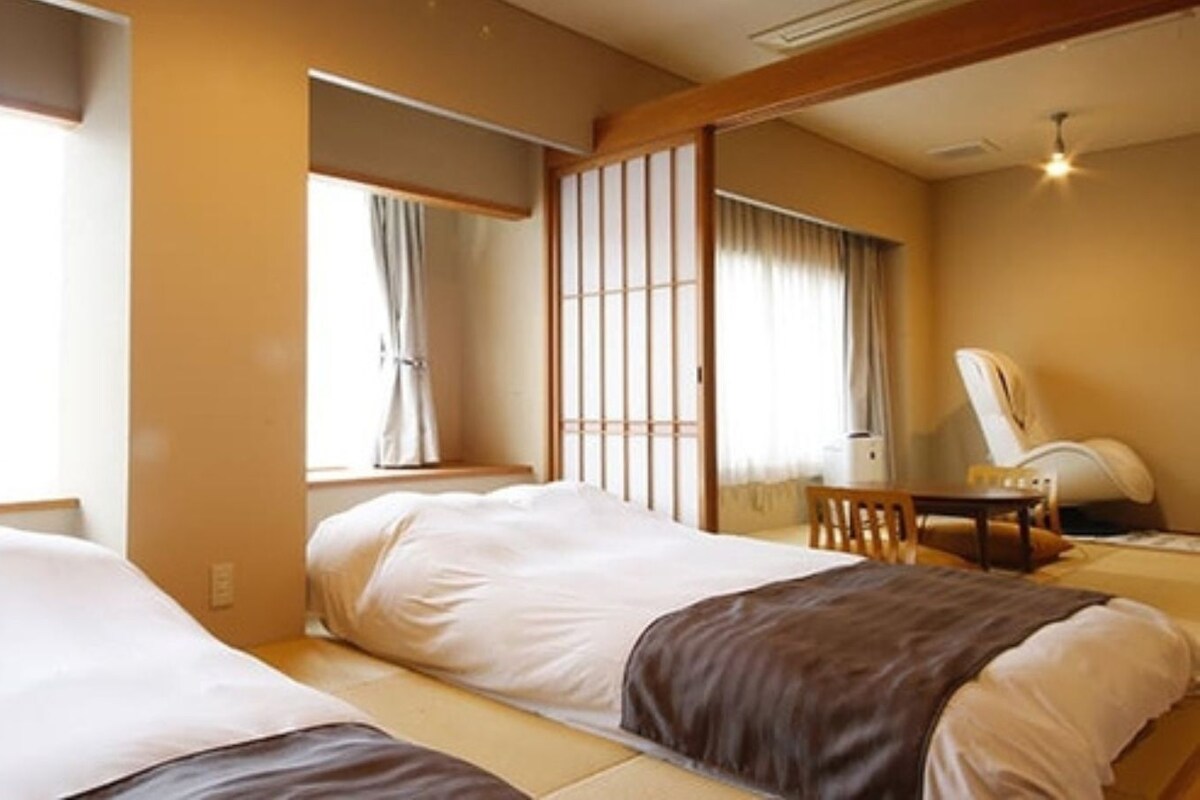 Una habitación de hotel con dos camas, un escritorio y una silla.
