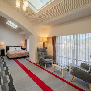 A hotel room with a bed, a grey armchair, a glass coffee table, and a large window with curtains. - Hotel Luna Park (Matsuyama)