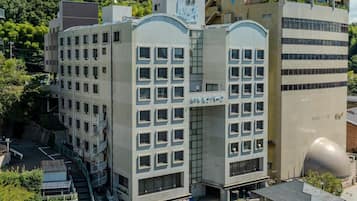 Un immeuble à plusieurs étages doté d’une architecture moderne, caractérisé par une façade incurvée remarquable et une grande structure sphérique située sur le côté droit.