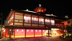 Un bâtiment traditionnel doté d’un toit particulier et d’une petite tour surmontée d’une statue.