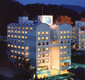 A multi-story hotel with a prominent sign, multiple windows, and a flat roof. - Hotel Luna Park (Matsuyama)