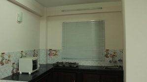Una cocina compacta con estufa a gas, microondas y pileta.