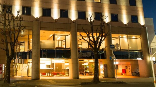 Hotel de vários andares com design moderno, apresentando um átrio central com assentos e uma escadaria.