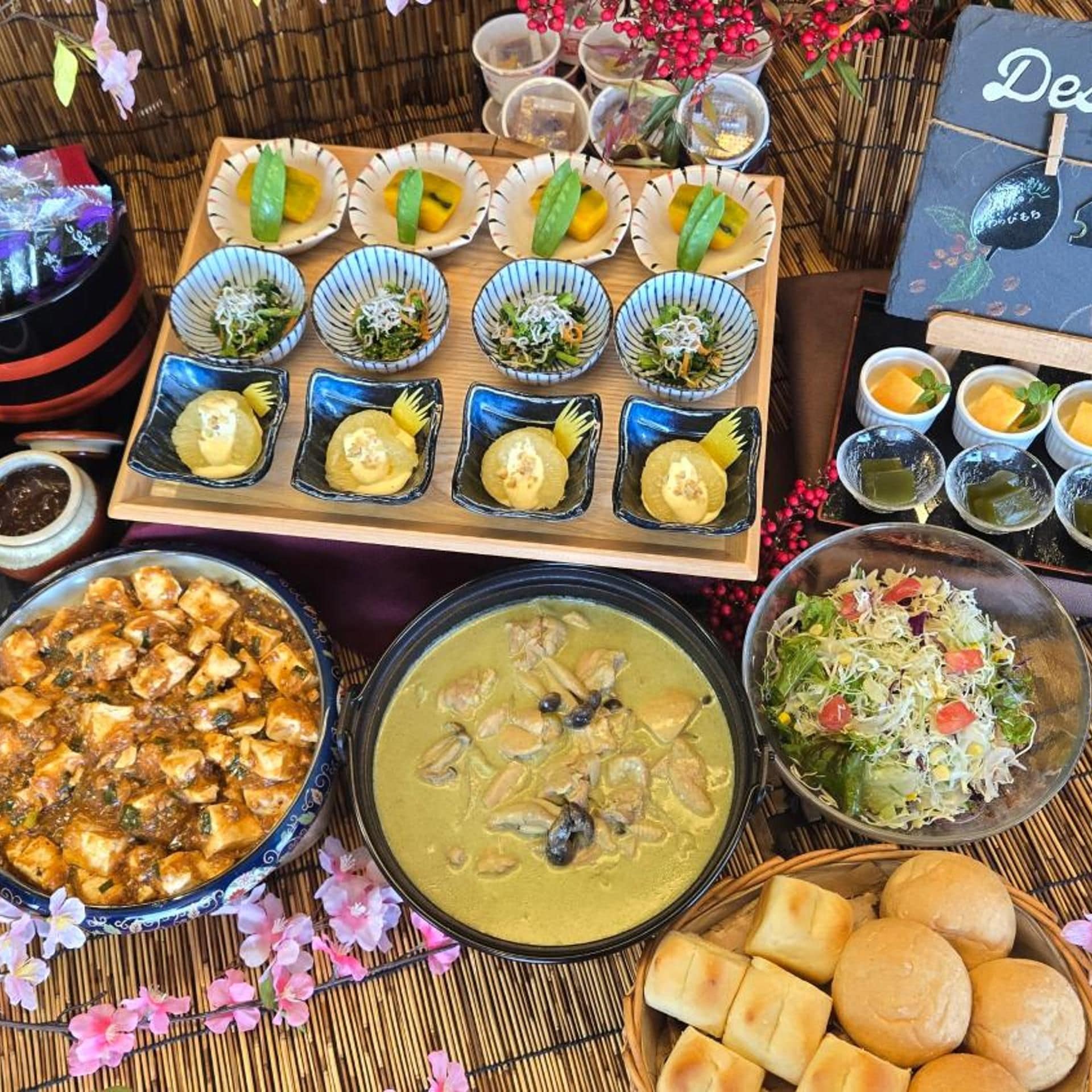 A variety of dishes and food items arranged on a table, including bowls of soup, a salad, and other dishes.