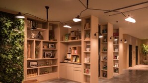 Un intérieur moderne avec des étagères en bois, un mur végétal et un sol carrelé.