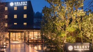 L’extérieur de l’hôtel Solest Takashino présente un design moderne, avec une entrée imposante et une signalétique bien éclairée.