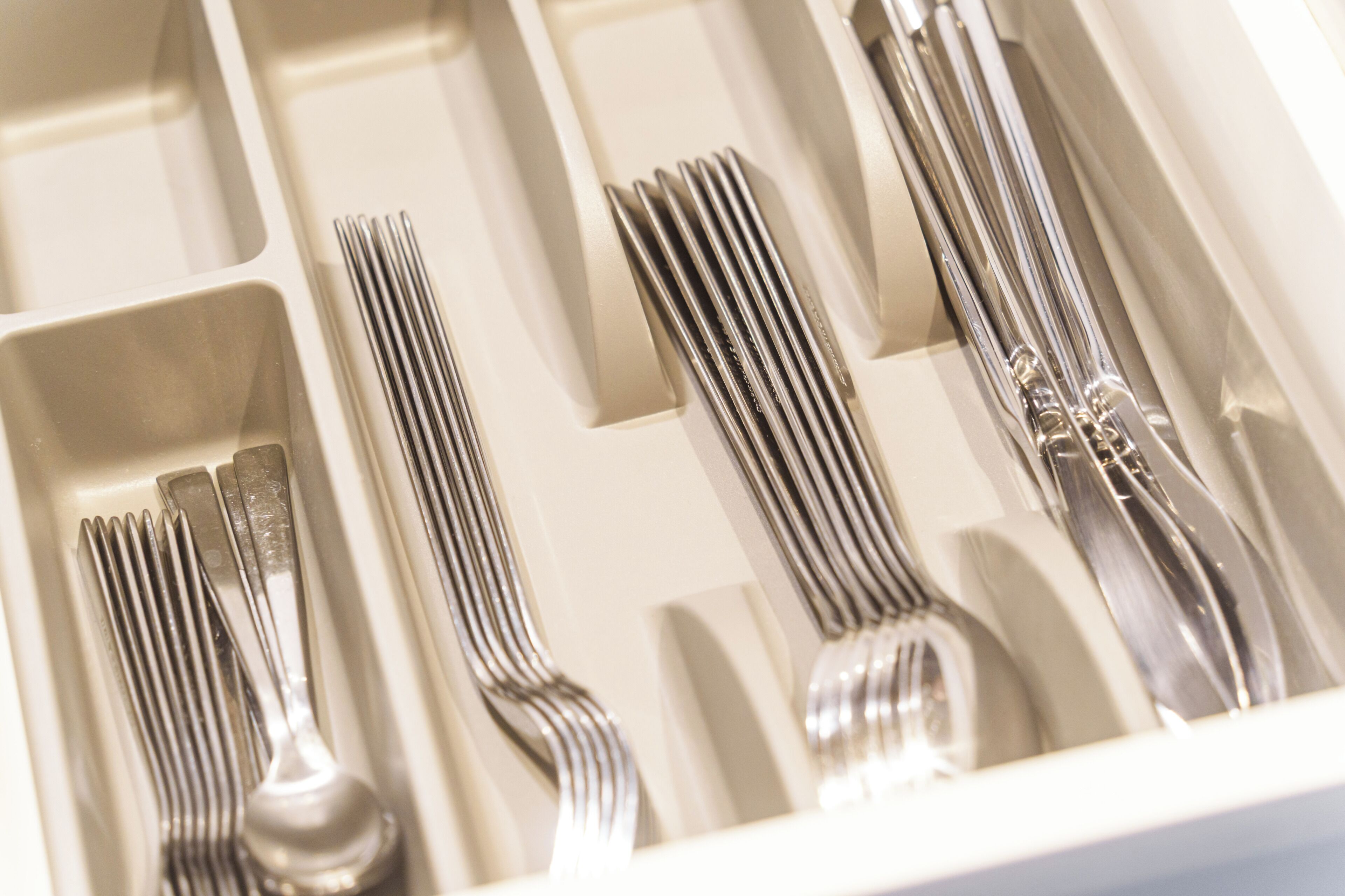 A drawer containing neatly arranged forks, knives, and spoons.