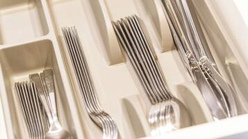A drawer containing neatly arranged forks, knives, and spoons.