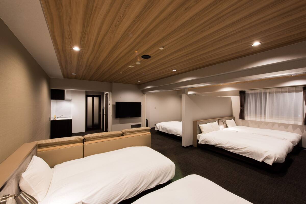 A hotel room with two beds, a television, and a mirror.