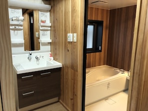 A bathroom with a wooden vanity, a sink, and a bathtub.