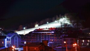 A hotel with a ski lift in the background, surrounded by snow-covered hills. - King David Bakuriani (Borjomi)