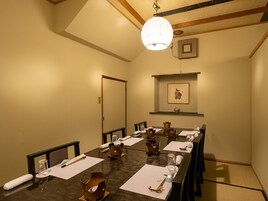 Una sala de conferencias con una larga mesa, sillas y una lámpara colgante.