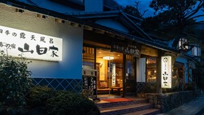 A traditional Japanese building with signage in Japanese, a wooden entrance, and a stone pathway leading to the door. - Shirayu no Yado Yamadaya (Hakone)