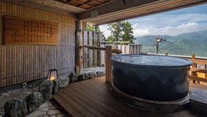 A traditional Japanese onsen with a wooden deck, a hot spring bath, and a view of mountains. - Shirayu no Yado Yamadaya (Hakone)