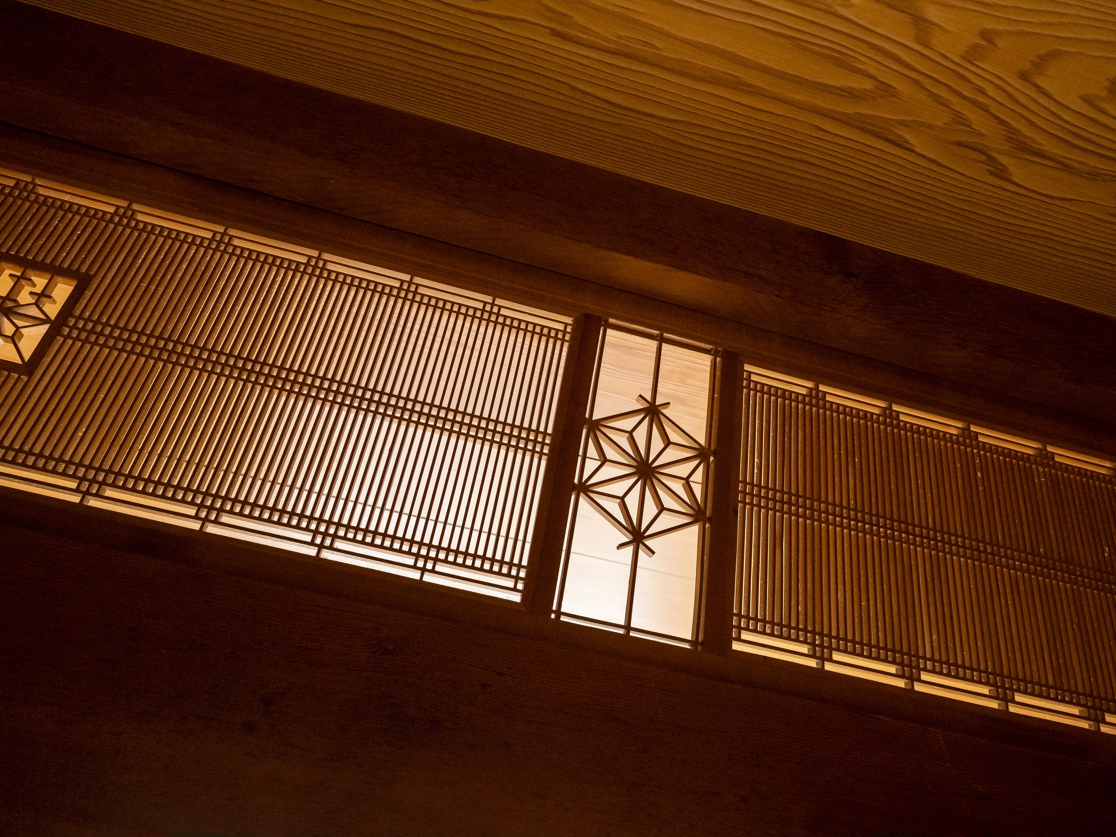 A traditional interior with wooden slats and a geometric window design.