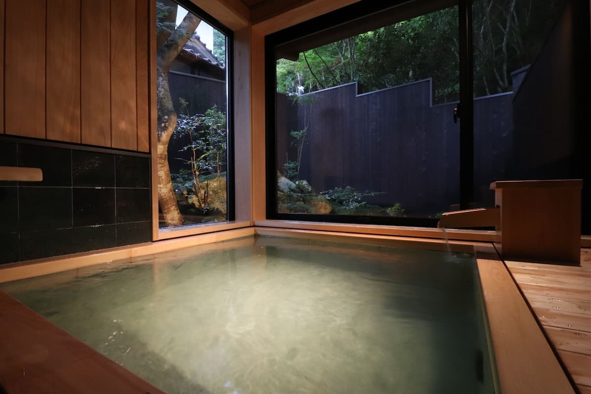 Un jacuzzi con vistas a una terraza de madera y un jardín.