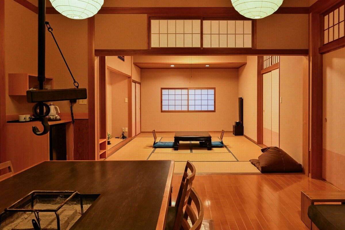Une pièce de style japonais traditionnel, avec un sol recouvert de tatamis, une table basse et des portes coulissantes.