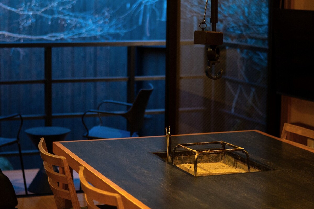 L’intérieur d’un restaurant comprend un bar, des tables et un écran de projection sur lequel est diffusée une image abstraite bleue.