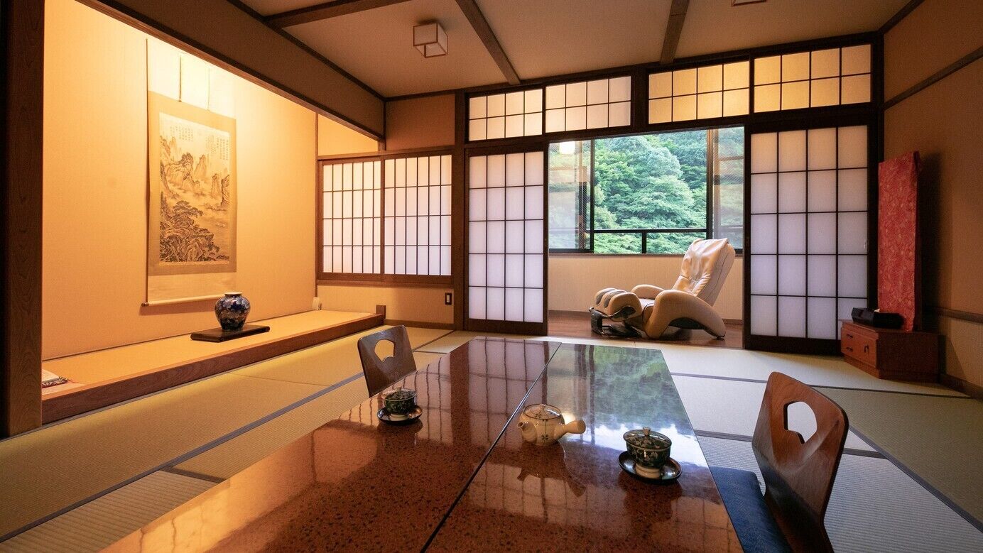 A traditional Japanese room with tatami flooring, a low table, and shoji screens.