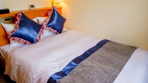 A hotel room with a bed, pillows, a bedside table, a lamp, and a wall clock. - Hotel Areaone Wadayama (Asago)