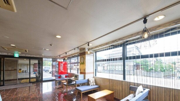 A spacious lobby with a Coca-Cola refrigerator, seating areas, and large windows. - Hotel Areaone Wadayama (Asago)