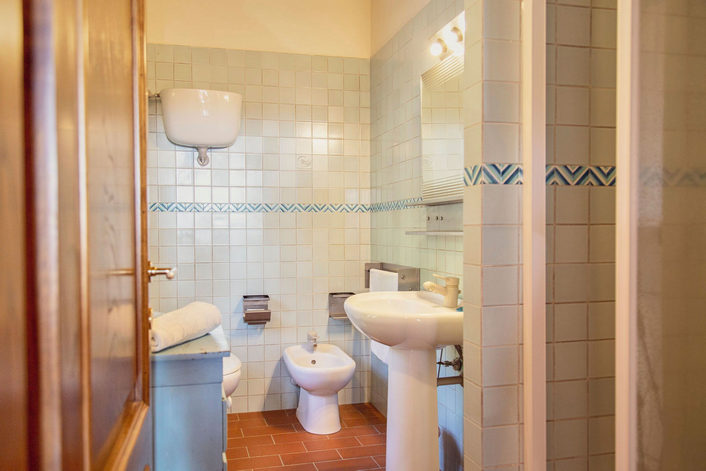 A bathroom with a toilet, bidet, and sink.