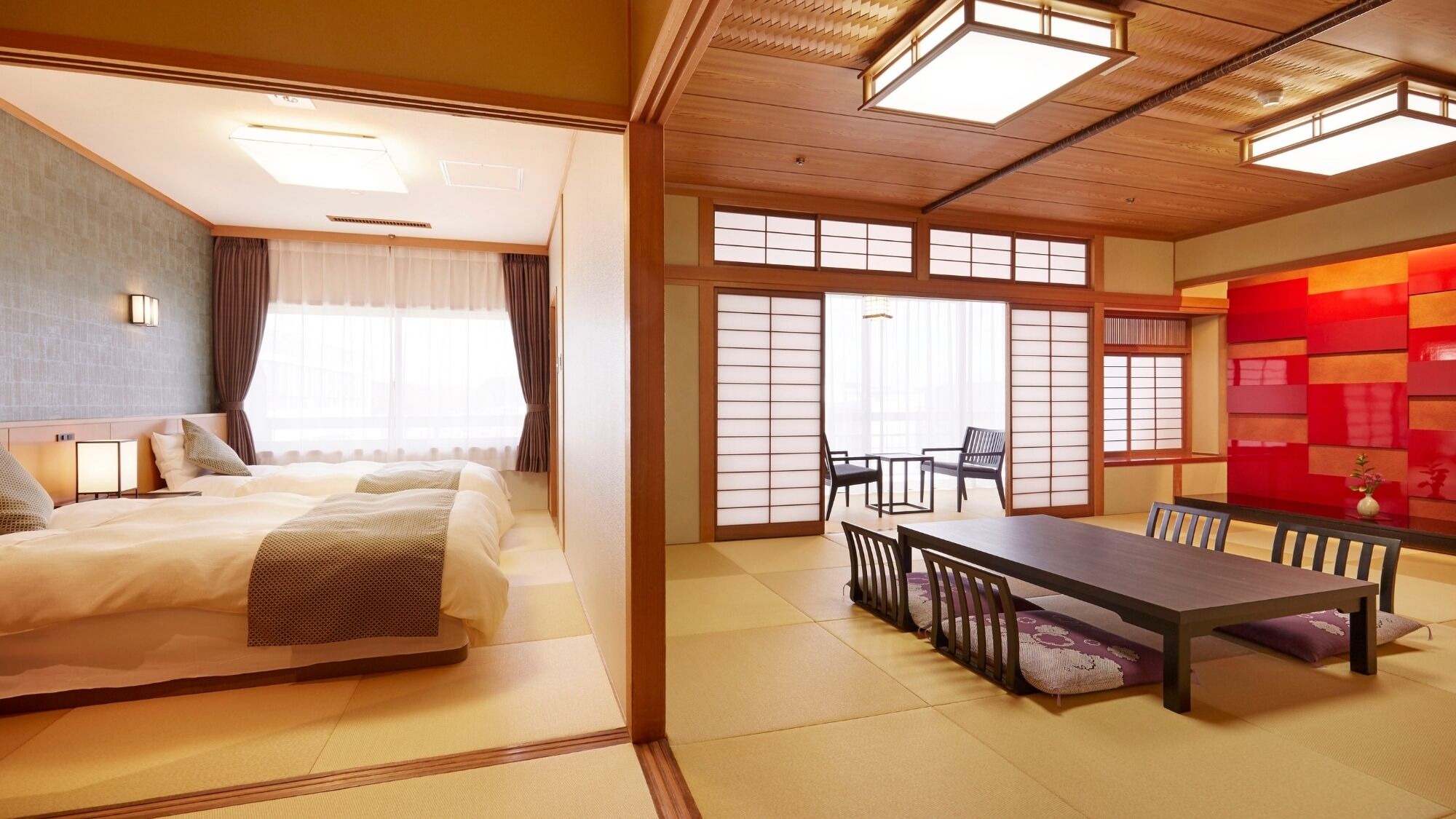 Habitación de hotel con cama, una mesa de comedor, sillas, una puerta corredera y vistas al exterior.