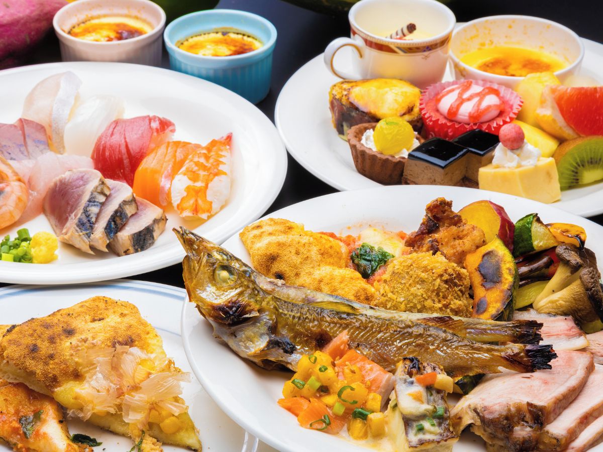 A variety of dishes including fish, vegetables, and desserts on a table.