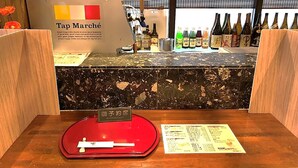 Un espace bar avec un comptoir en marbre, une balance rouge et un menu.