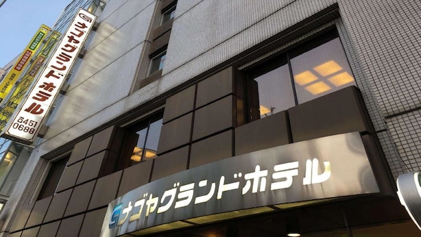 Un bâtiment sur lequel on peut lire l’inscription « Sakura Hotel » en anglais et en japonais.