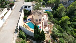 An aerial view of a residential area with a swimming pool, a small tower-like structure, and surrounding greenery. - Modern, well maintained villa with stunning sea views, private pool, Wi-Fi, air conditioning (Denia)