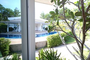 A view of a house with a swimming pool, surrounded by greenery and a clear sky. - Yokyor Resort (Sikao)