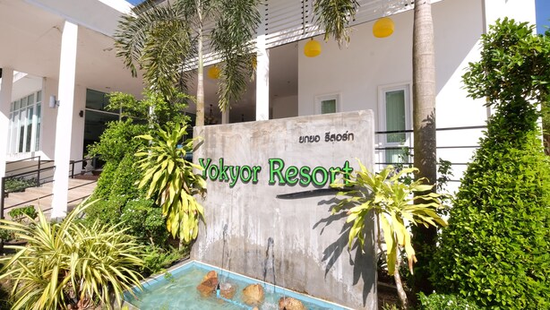 Yokyor Resort's exterior with a sign, a pool area, and surrounding greenery. - Yokyor Resort (Sikao)