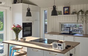 A kitchen with a built-in oven, a sink, and a radio.