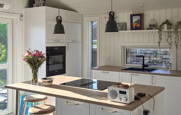 A kitchen with a built-in oven, a sink, and a radio.