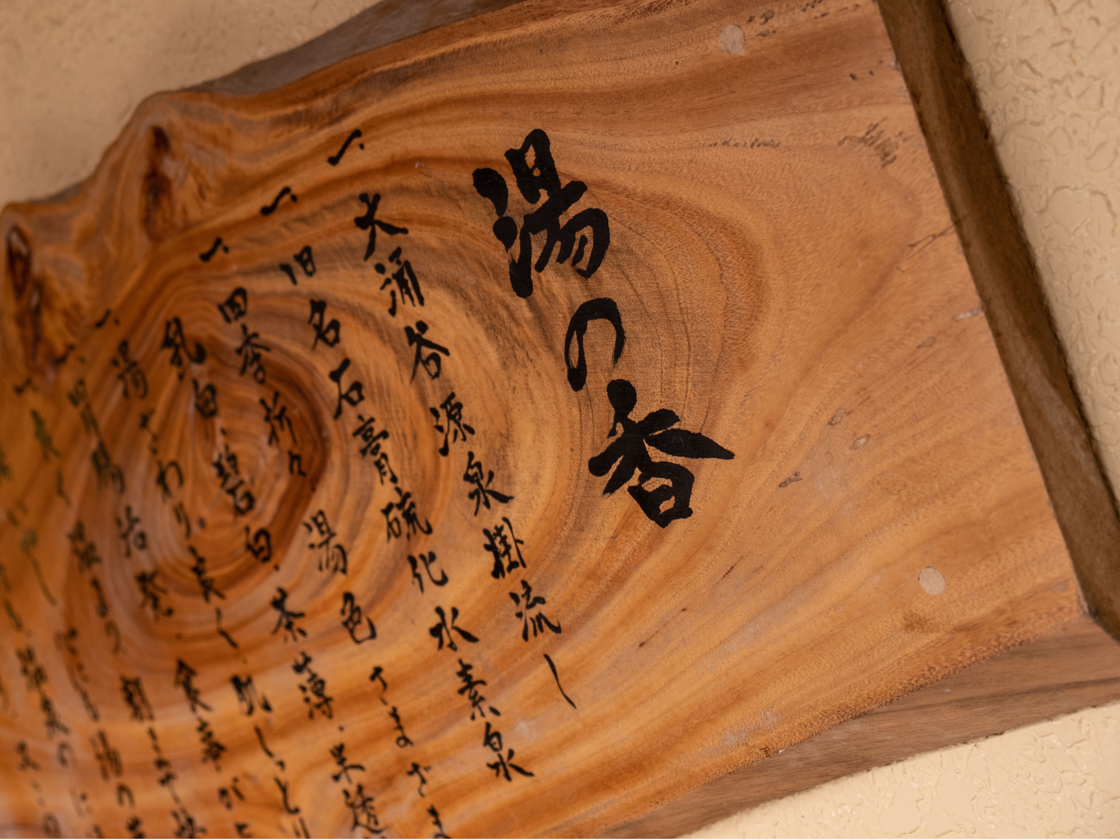 A wooden plaque with carved Chinese characters.