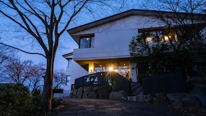 A modern two-story house with a stone pathway leading to the entrance. - Hotel Kasansui (Hakone)