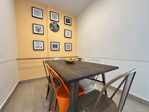 Ein Essbereich mit Tisch, Stühlen und einer Wand, die mit gerahmten Bildern dekoriert ist.