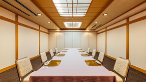 A conference room with a long table, chairs, and a ceiling with recessed lighting. - Urban Hotel (Nihommatsu)