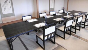 A conference room with a long table, chairs, and a whiteboard.
