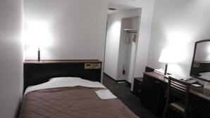 A hotel room with a bed, a desk, a chair, a mirror, and a wardrobe.
